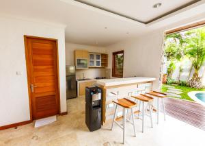una cucina con bancone e alcuni sgabelli di Villa Suzuki 2 Seminyak a Seminyak