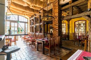 a restaurant with tables and chairs in a room at Landhotel Zur Scheune in Röbel