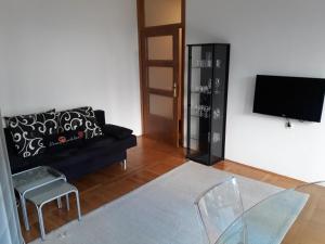 a living room with a black couch and a tv at Peace & Love in Zagreb