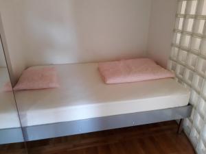 a small room with a bed with pink sheets at Peace & Love in Zagreb