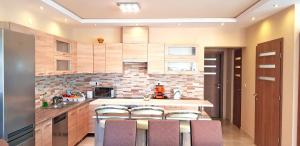 a kitchen with a counter and some chairs in it at Central-Aqua Apartman in Gyula