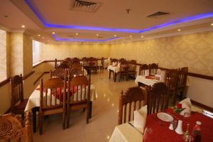 a restaurant with tables and chairs in a room at Wave International Hotel in Dubai