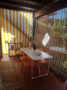 una mesa y sillas blancas en una habitación con ventana en Villino Le Luccine, en Puntaldia
