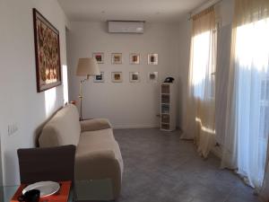 uma sala de estar com um sofá e uma janela em Appartamento Le Cupole em Pádua