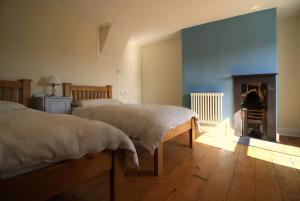 a bedroom with two beds and a fireplace at 20 Segontium Terrace in Caernarfon