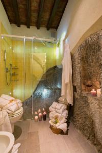 a bathroom with a shower and a toilet and candles at Belvedere in Cortona