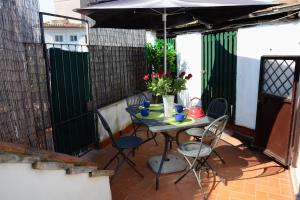 a table with chairs and an umbrella on a patio at Appartamento Coronari in Rome