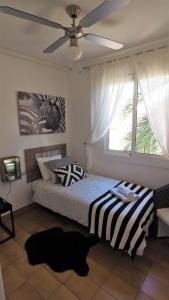 マズノウにあるCristina Port & Beach - Apartmentのベッドルーム1室(ベッド1台、シーリングファン付)