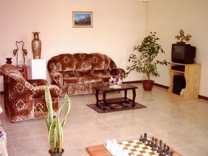 a living room with a couch and a chess board at Alpha Villa - Studios without kitchen in Flic-en-Flac