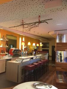 ein Restaurant mit einer Bar mit Barhockern in der Unterkunft Kunstcafe Rooms in Stegersbach