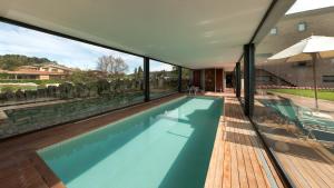 a swimming pool with a view of a house at Mas Albereda in Sant Juliá de Vilatorta