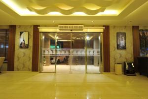 un vestíbulo con una puerta de cristal en un edificio en Al Janaderia Suites 7, en Riad