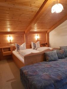 a bedroom with two beds in a wooden cabin at Ferienhaus Weps in Arnbruck