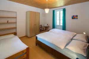 a bedroom with two beds and a window at Hotel Garni Maggia in Coglio