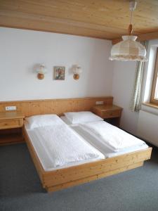 ein Schlafzimmer mit einem Holzbett und zwei Nachttischen in der Unterkunft Honsnhof in Tux