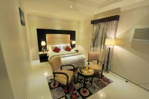 Un dormitorio con una cama y una mesa y sillas. en Al Janaderia Suites 7, en Riad