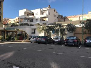 un estacionamiento con autos estacionados frente a un edificio en Camera con Vista, en Oristano