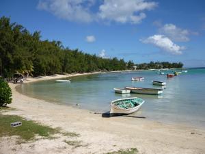 a group of boats on the shore of a beach at Alpha Villa - Studios without kitchen in Flic-en-Flac