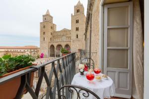 a table on a balcony with a view of a cathedral at Palazzo Maria in Cefalù
