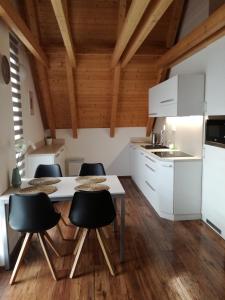 - une cuisine avec des placards blancs, une table et des chaises dans l'établissement Apartmán NIKI Apollon Resort Lednice, à Lednice