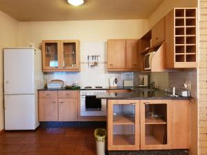 a kitchen with wooden cabinets and a white refrigerator at Crocodile Lodge cc in Midrand