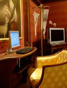 a desk with a computer on a table with a chair at Hotel Kette in Venice