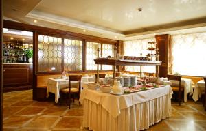 um restaurante com mesas e toalhas de mesa brancas em Hotel Kette em Veneza