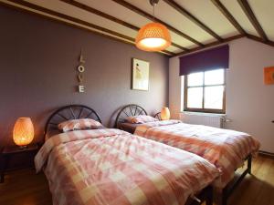 two beds sitting next to each other in a bedroom at Cozy Holiday Home in Noville with Private Terrace in Luzery