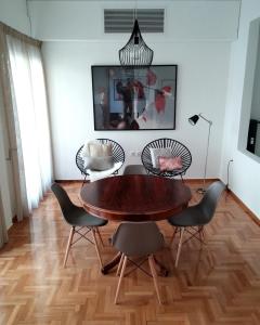 een eetkamer met een houten tafel en stoelen bij New stylish Kolonaki flat in Athene