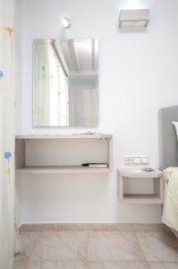 Dieses weiße Zimmer verfügt über ein Fenster und einen Spiegel. in der Unterkunft Pension Elena in Agia Anna