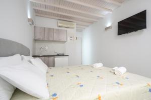 Biały pokój z łóżkiem i kuchnią w obiekcie Pension Elena w mieście Agia Anna (Naxos)