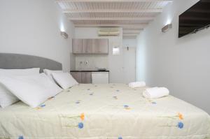 una camera da letto con un grande letto bianco con fiori di Pension Elena ad Agia Anna Naxos