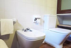 a bathroom with a white toilet and a sink at Villa Font March in Pollença +30 photos
