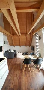 - un salon avec des plafonds en bois, une table et des chaises dans l'établissement Apartmán NIKI Apollon Resort Lednice, à Lednice