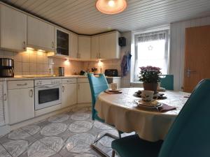 a kitchen with a table and blue chairs and a kitchen with a table and chairs at Modern Apartment in Rakow with Barbecue in Rakow