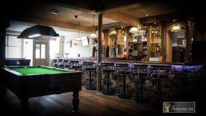 una mesa de billar frente a un bar con taburetes en The Enniskerry Inn en Enniskerry