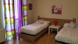two beds in a room with colorful curtains at Antico Casale in Turin