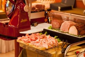 a counter with meat and meats on a cutting board at Villa Nicolli Romantic Spa Resort - Adults Only in Riva del Garda