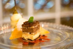 a piece of cake on a clear glass plate at Villa Nicolli Romantic Spa Resort - Adults Only in Riva del Garda