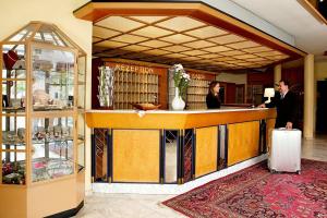 two people standing at a bar in a store at Rheinhotel Vier Jahreszeiten Bad Breisig in Bad Breisig