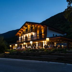 a building with people sitting outside of it at night at Atmospheres in Le Bourget-du-Lac +45 photos