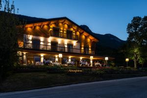 a large building with people sitting on the porch at night at Atmospheres in Le Bourget-du-Lac