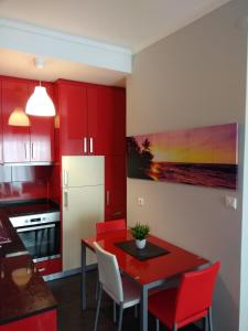 ポルトにあるML Apartments Almiranteのキッチン(赤いキャビネット、テーブル、赤い椅子付)