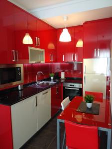 eine rote Küche mit roten Schränken und einem roten Tisch in der Unterkunft ML Apartments Almirante in Porto