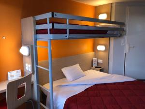a bedroom with a bed and a desk at Premiere Classe Perpignan Sud in Perpignan