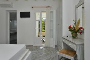 a white room with a table and a mirror at Surfing Beach Village Paros in Santa Maria