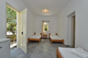 a white room with a table and chairs and a window at Surfing Beach Village Paros in Santa Maria