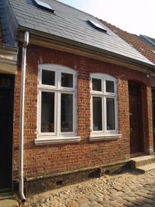 a brick house with two windows on it at Peder Dovns Slippe in Ribe