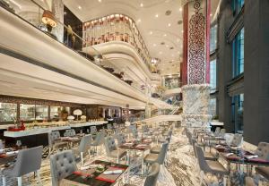 a restaurant with tables and chairs in a building at The Reverie Saigon Residential Suites in Ho Chi Minh City