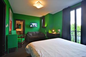 ヴィエルゾンにあるLogis - Hotel Restaurant La Mireの緑のベッドルーム(ベッド1台、ソファ付)
